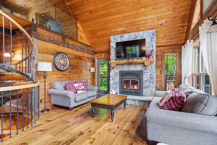 Log great room with a stone hearth