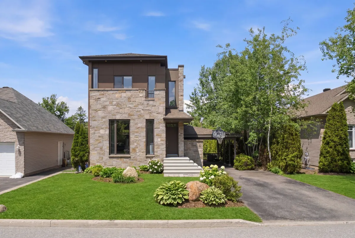 Maison moderne en pierre et bois avec terrain paysager à l’avant