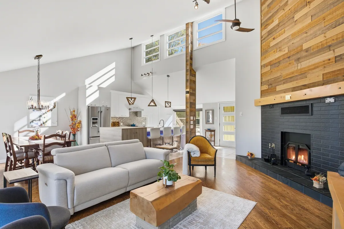 Bright double-height living room with a wood feature wall and a fireplace