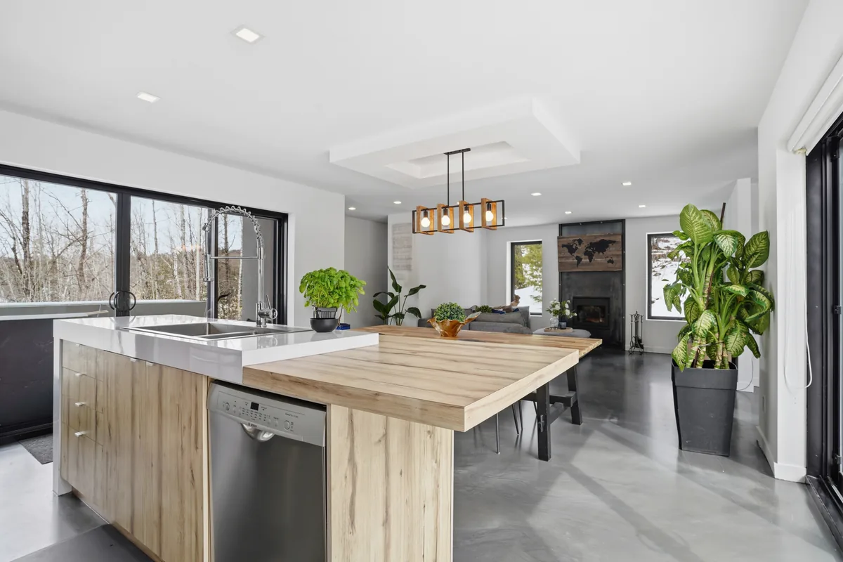 Open kitchen island and living space with a contemporary fireplace and a snowy view