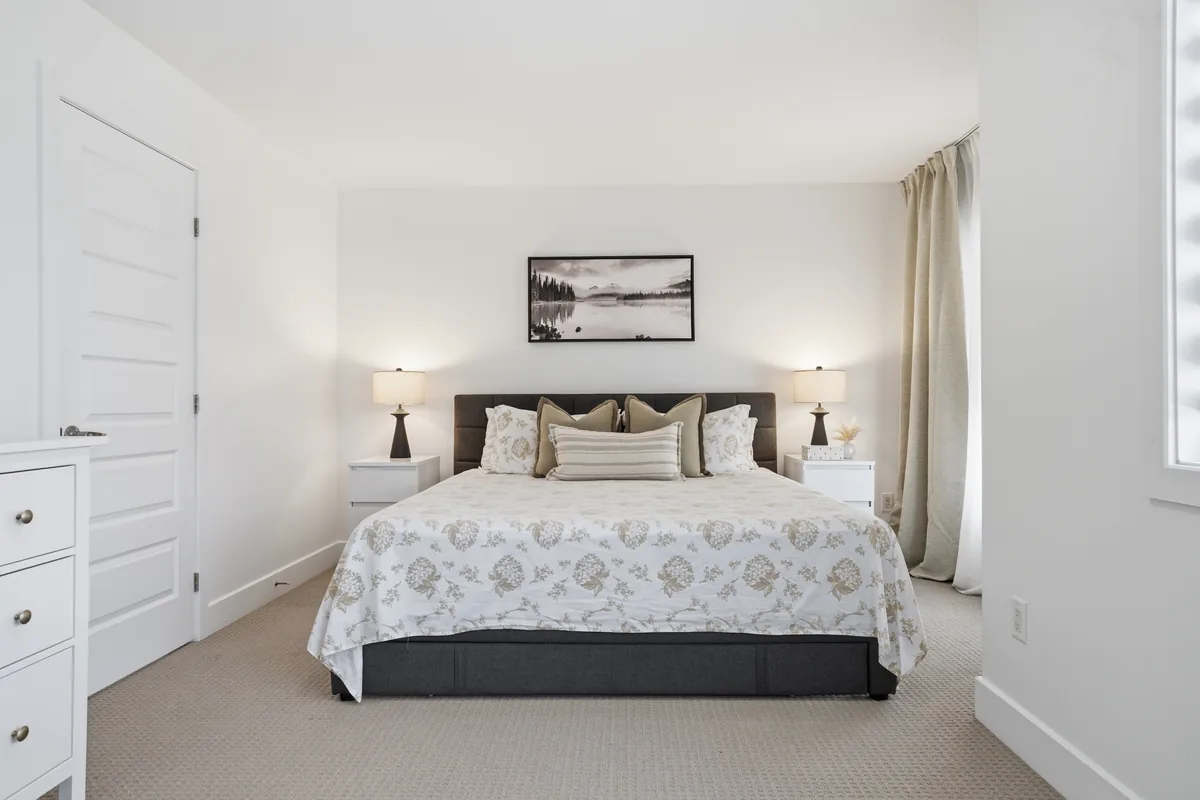 Warm primary bedroom with an upholstered bed, bedside lamps and neutral decor